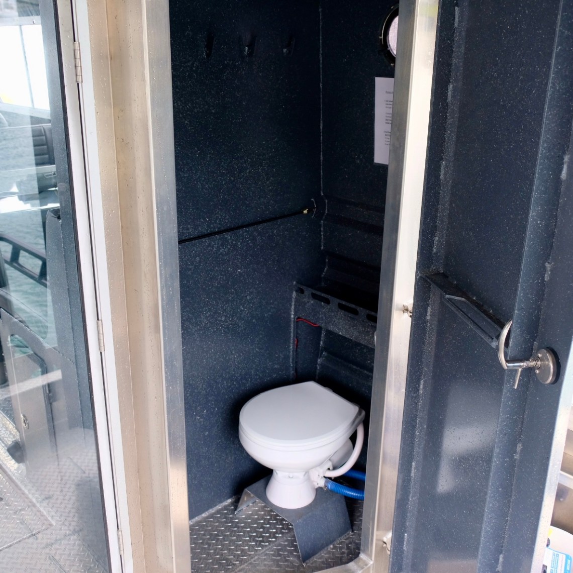 A small boat bathroom with a toilet and metal walls.
